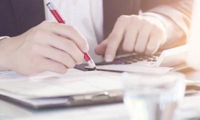 Jemand kalkuliert etwas an einem Schreibtisch